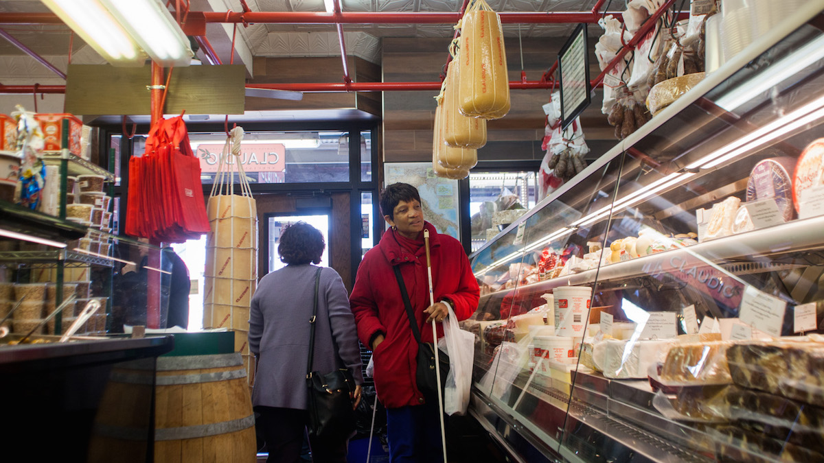  Denice Brown visits a cheese and meat shop during a Philly Touch Tour of the Italian Market. (Brad Larrison/for NewsWorks) 