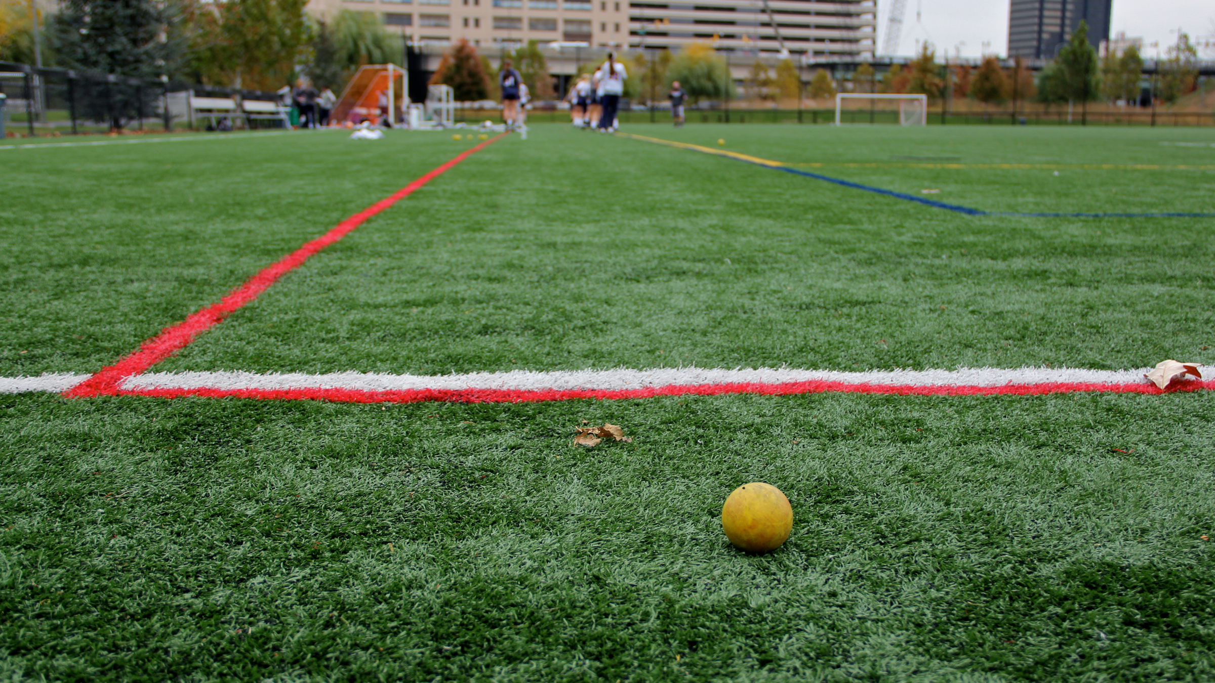 A lacrosse team practices on the artificial turf at Penn Park in Philadelphia. (Emma Lee/WHYY)
