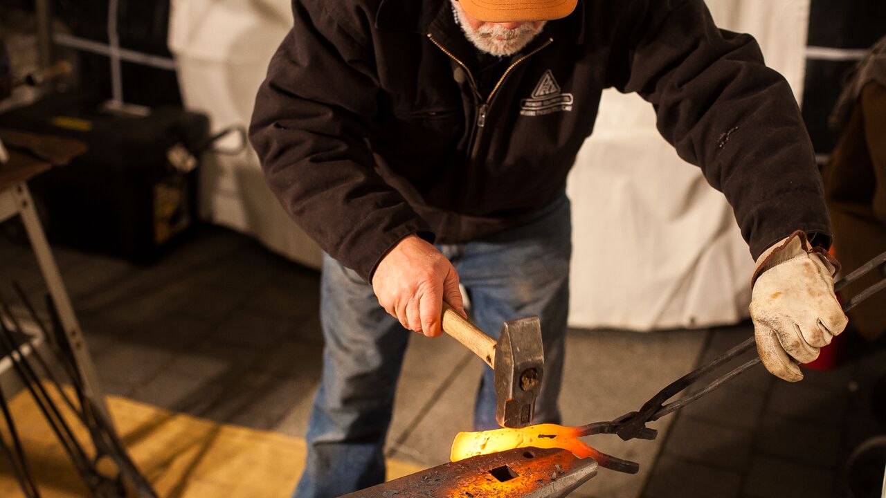  Blacksmith Mike Martin, who founded the Colorado-based nonprofit RawTools after the 2012 Sandy Hook shooting, transforms a rifle into a farm tool Wednesday night. (Brad Larrison/ for NewsWorks) 