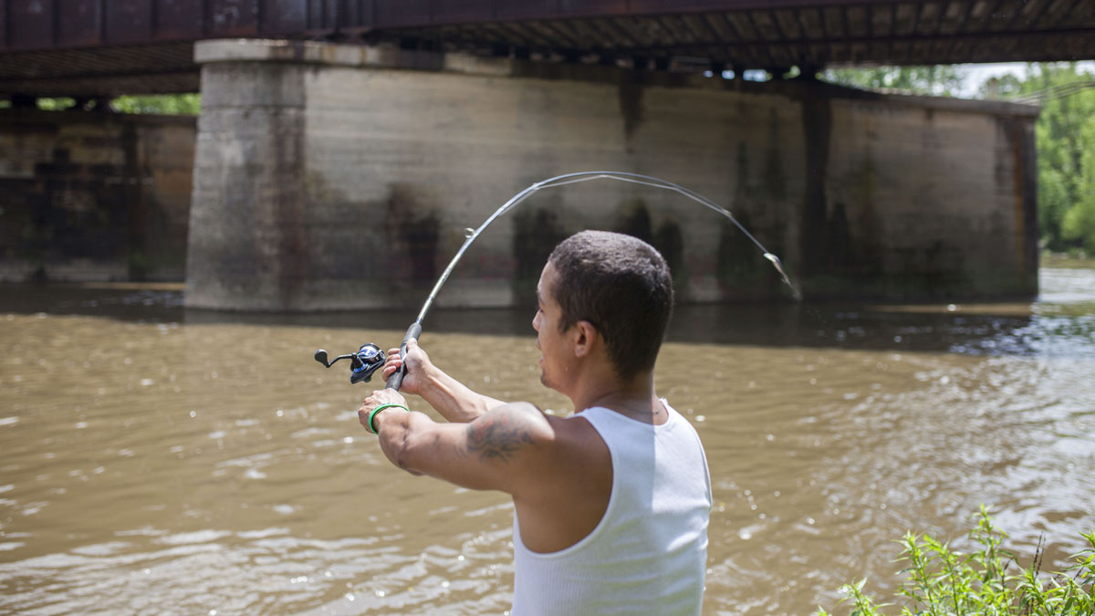 Jeremy Viejegas casts his line into the Schuylkill River in Reading. (Jessica Kourkounis/for WHYY)