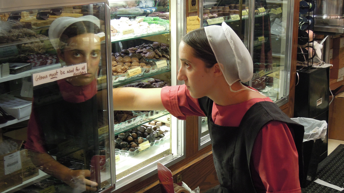  A young woman fills boxes of candy at Sweet as Fudge Candy Shoppe.  (Photo by Understanding Allah) 
