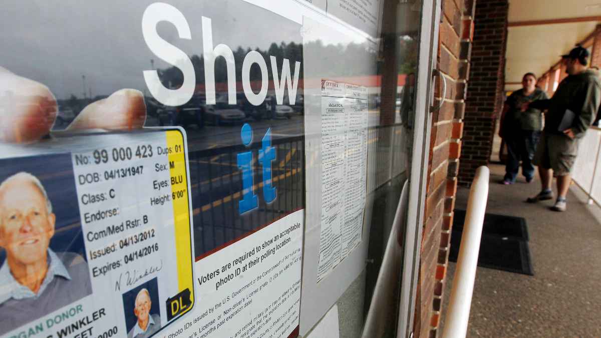  People pass the signs telling of the requirement for voters to show an acceptable photo ID to vote as they head into the the PennDOT Drivers License Center in Butler, Pa. (AP Photo/Keith Srakocic, file) 
