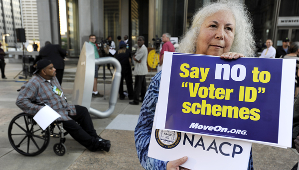  In this September 2012 photo, a protestor holds a sign during the NAACP voter ID rally to demonstrate the opposition of Pennsylvania's voter identification law, which requires each voter to show valid photo identification. (Michael Perez/AP Photo, file) 