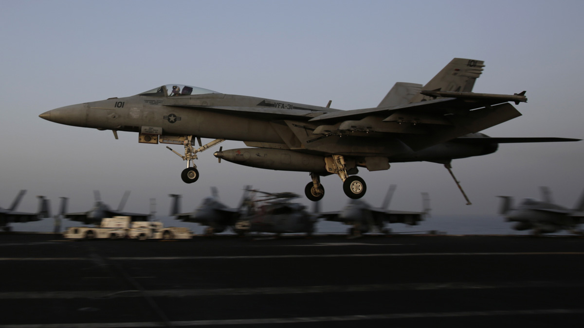  An F/A-18C Hornet coming from Iraq lands on the flight deck of the U.S. Navy aircraft carrier USS George H.W. Bush, Sunday, Aug. 10, 2014, in the Persian Gulf. Aircraft aboard the George H.W. Bush are flying missions over Iraq after U.S. President Barack Obama authorized airstrikes against Islamic militants and food drops for Iraqis trapped by the fighters. (AP Photo/Hasan Jamali) 