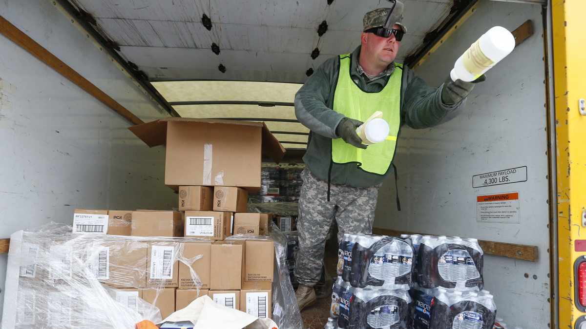 Michigan National Guard Staff Sgt. James Green hands out a water test kit to be distributed to residents