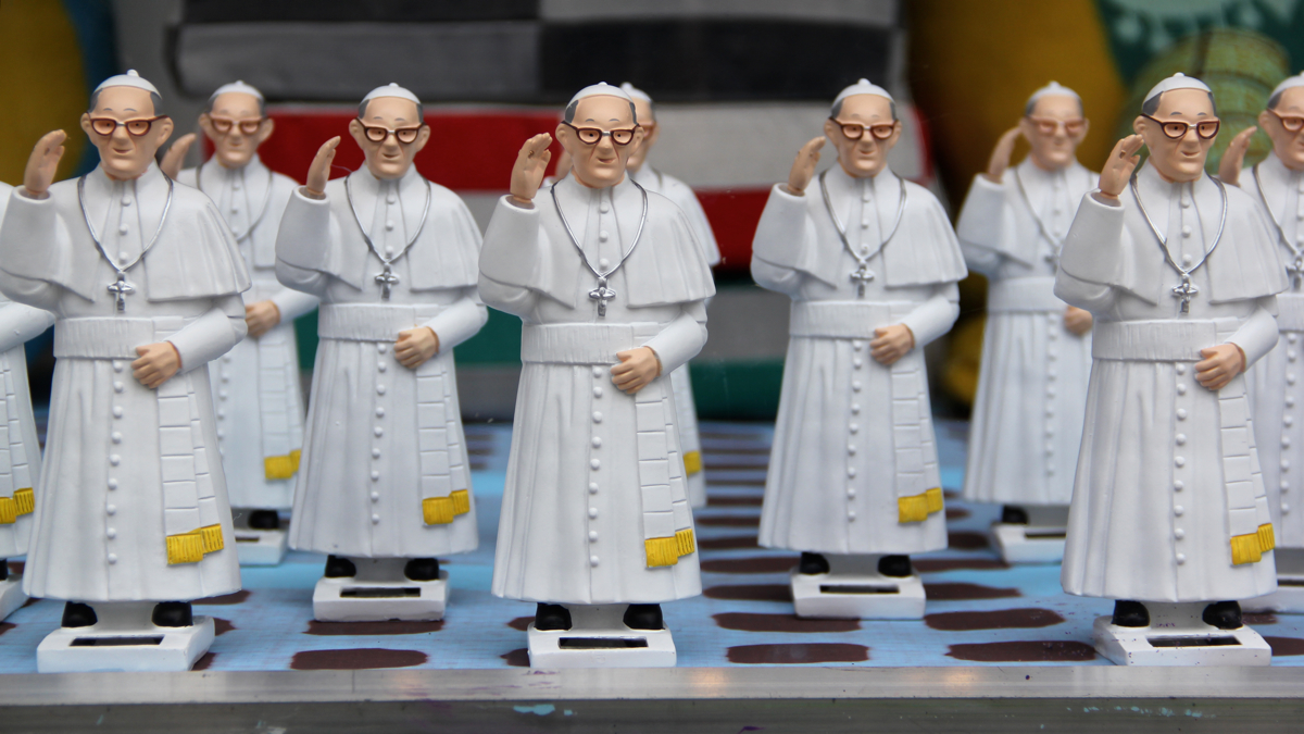  A window display at The Fabric Workshop (1214 Arch Street) features an array of waving Pope Francis statues. (Emma Lee/WHYY) 