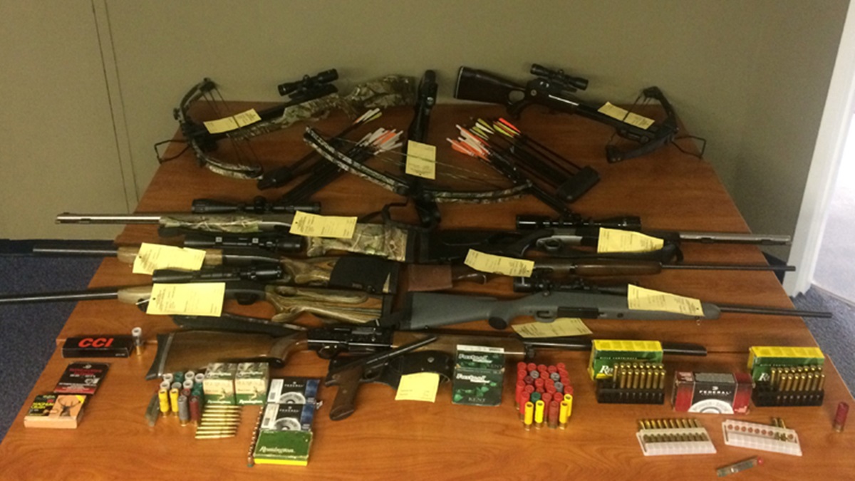  Police display weapons they seized including three crossbows, three shotguns, two muzzleloaders, two rifles, one handgun and a number of arrows and ammunition. (photo courtesy DNREC) 