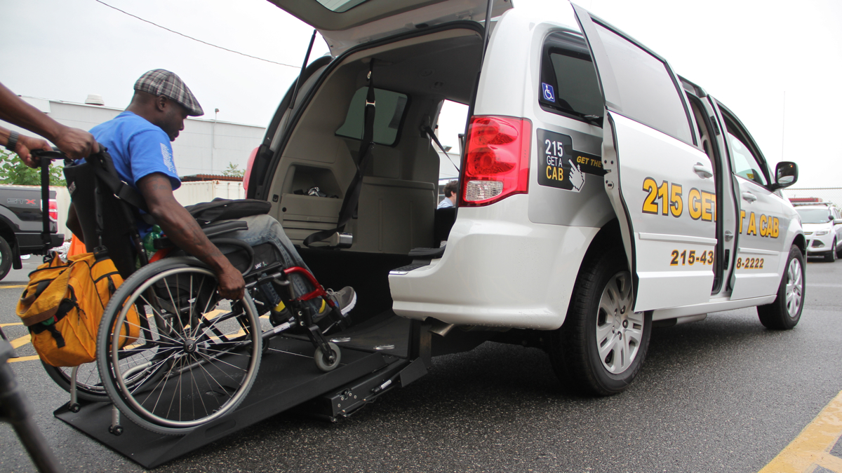 Tony Brooks tries out Philadelphia's new wheelchair accessible taxi in the parking lot of the Philadelphia Parking Authority's Taxicab and Limousine Division. (Emma Lee/WHYY)