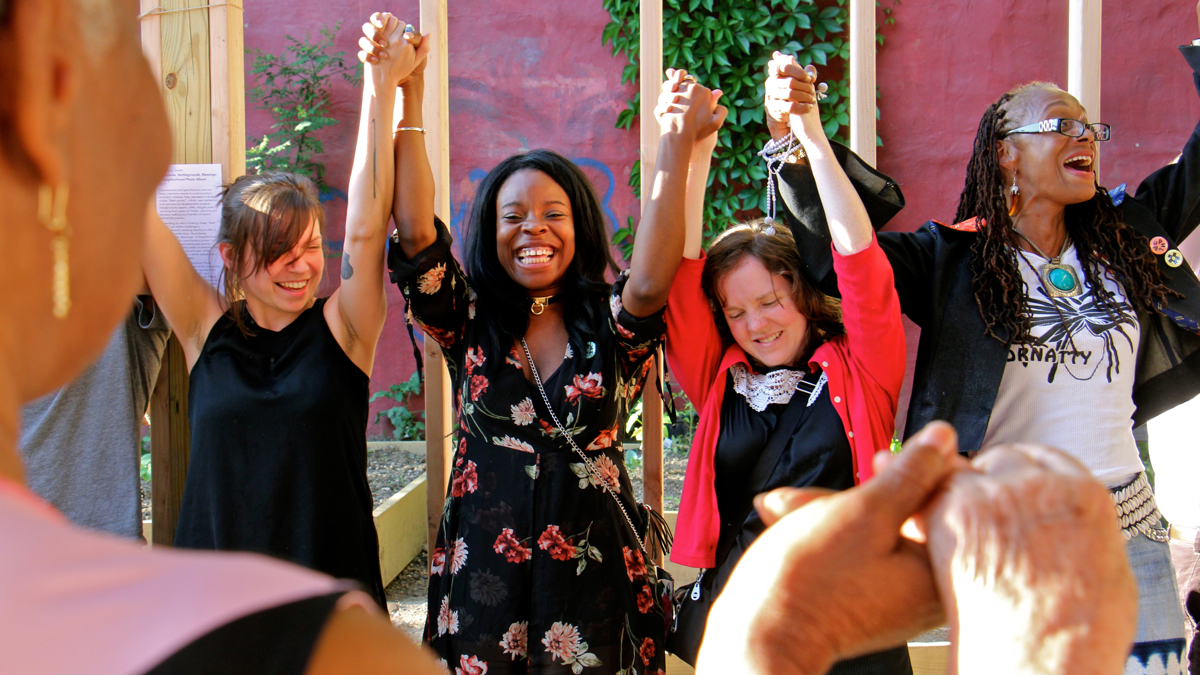 Participants in the ''Philadelphia Assembled'' civic engagement project invent a housewarming ritual for a new performance and exhibit space at Tillmon Community Garden in Kensington. (Emma Lee/WHYY)