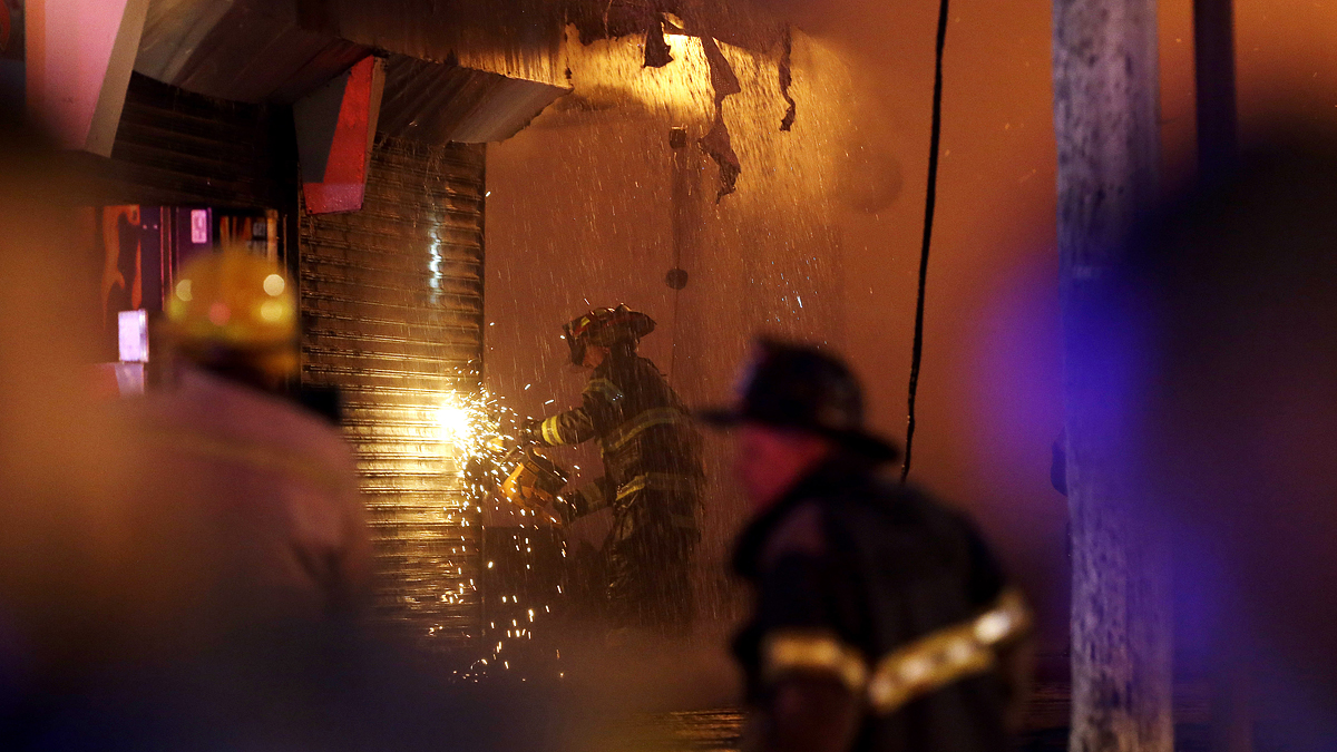  A firefighter saws through a metal wall  on Thursday in Seaside Park, N.J. (AP Photo/Julio Cortez) 