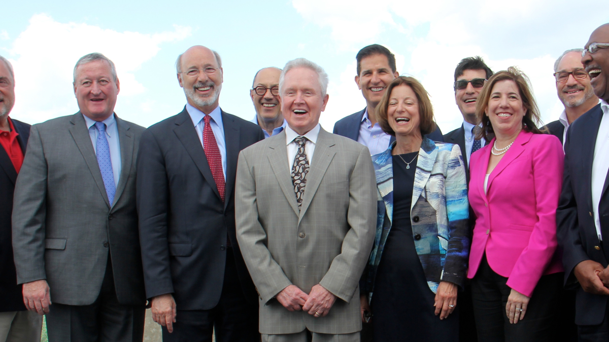  Tom Corcoran (center), outgoing president of the Delaware River Waterfront Corporation, poses for a photo after announcing funding for the Penn's Landing cap and civic space. (Emma Lee/WHYY, file) 