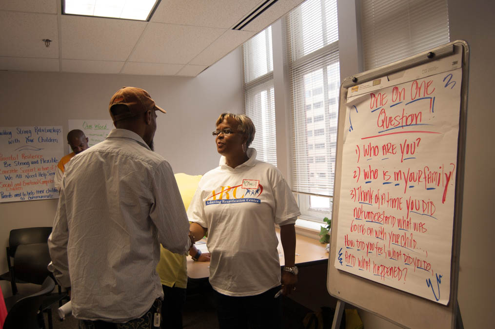  An ARC service provider chats with a father involved after the Parents Cafe. (Ann Marie Awad/for NewsWorks) 
