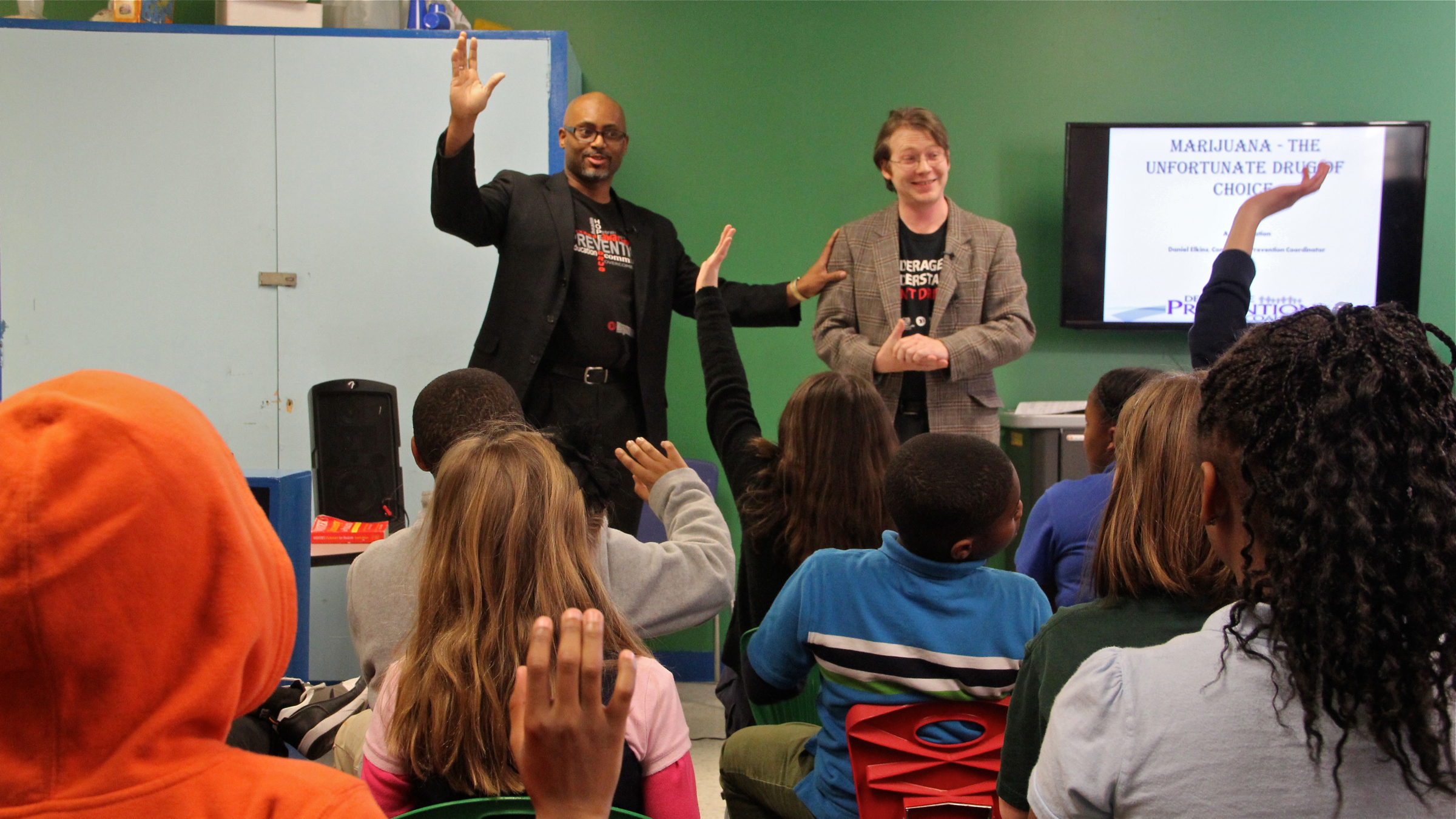  Community prevention coordinators John Hampton (left) and Daniel Elkins present an anti-drug program to children at the Bellevue Community Center in Wilmington, Delaware. (Emma Lee/WHYY) 
