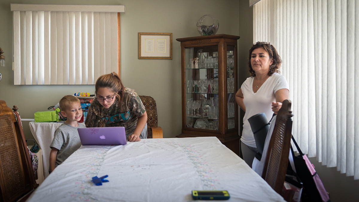 Alessia and her son Jared stand over her computer in grandmother Carmelina Mattioli’s house in Glassboro