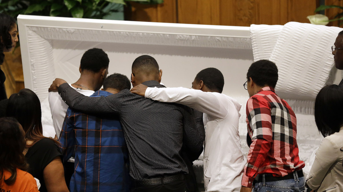  Mourners embrace as they gather in front of the casket containing the body of Freddie Gray before his funeral, Monday, April 27, 2015, at New Shiloh Baptist Church in Baltimore. Gray died from spinal injuries about a week after he was arrested and transported in a Baltimore Police Department van. (AP Photo/Patrick Semansky) 