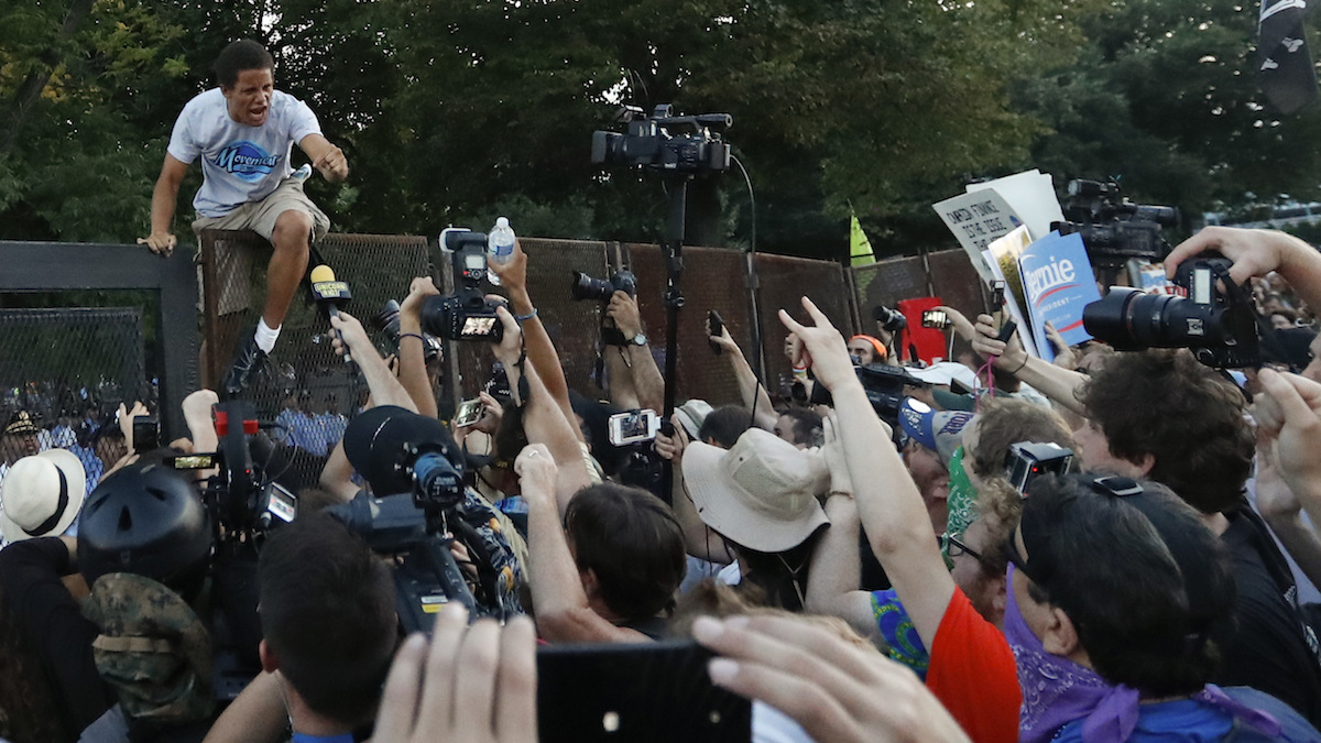 A protester climbs over the fence near the AT&T Station in Philadelphia