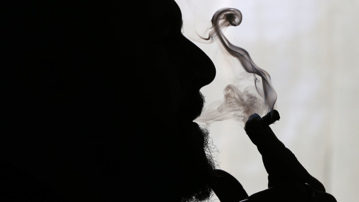  File - In this Nov. 21, 2014 file photo, former U.S. Marine Sgt. Ryan Begin smokes medical marijuana at his home in Belfast, Maine. (AP Photo/Robert F. Bukaty, File) 