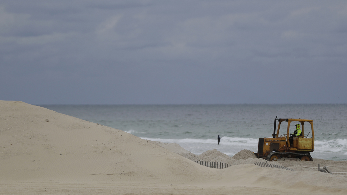 A worker pushes sand onto a protective sand dune in Seaside Heights