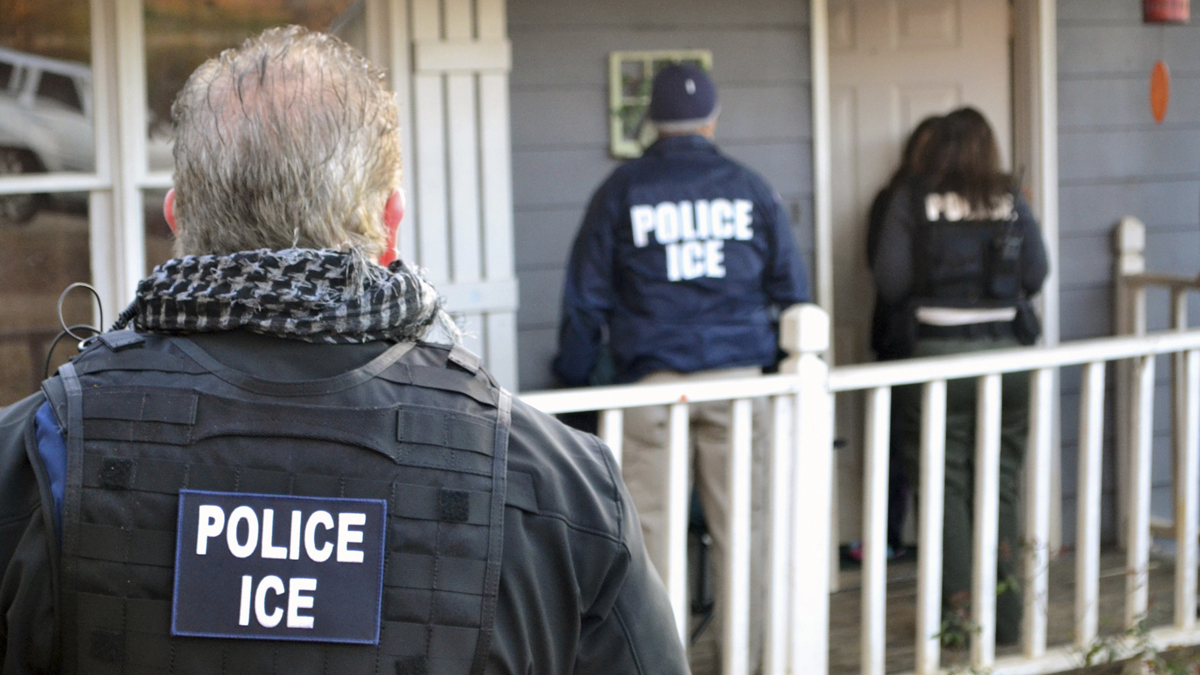 In this file image, U.S. Immigration and Customs Enforcement agents arrive at a home during a targeted enforcement operation.  (Bryan Cox/ICE via AP) 