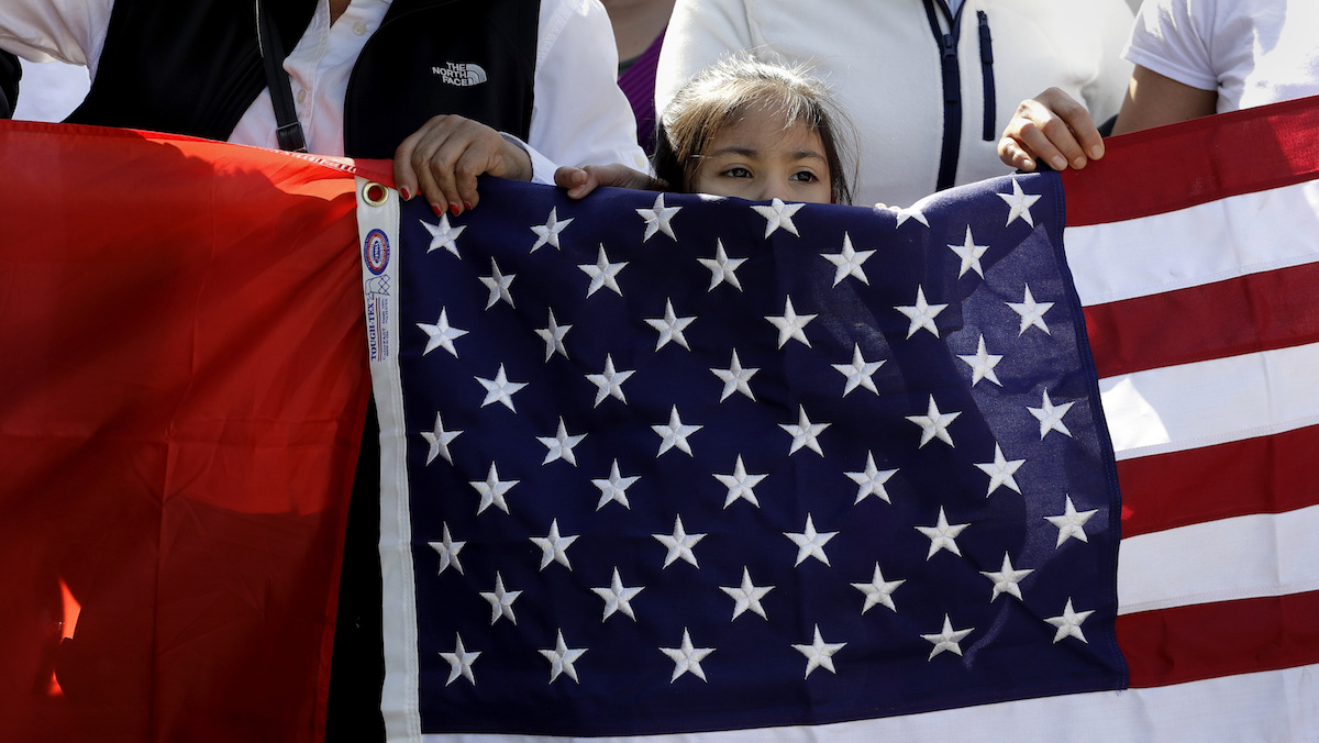 A young girl helps hold a U.S. flag as a group marches toward the Texas Capitol during an immigration protest last month in Austin, Texas. (AP Photo/Eric Gay) 