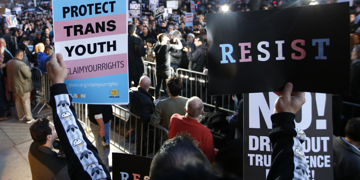  A participant holds signs from a stoop next door to the Stonewall National Monument during a rally in support of transgender youth Thursday in New York. Supporters spoke out against President Donald Trump's decision to roll back a federal rule saying public schools had to allow transgender students to use the bathrooms and locker rooms of their chosen gender identity. (AP Photo/Kathy Willens) 