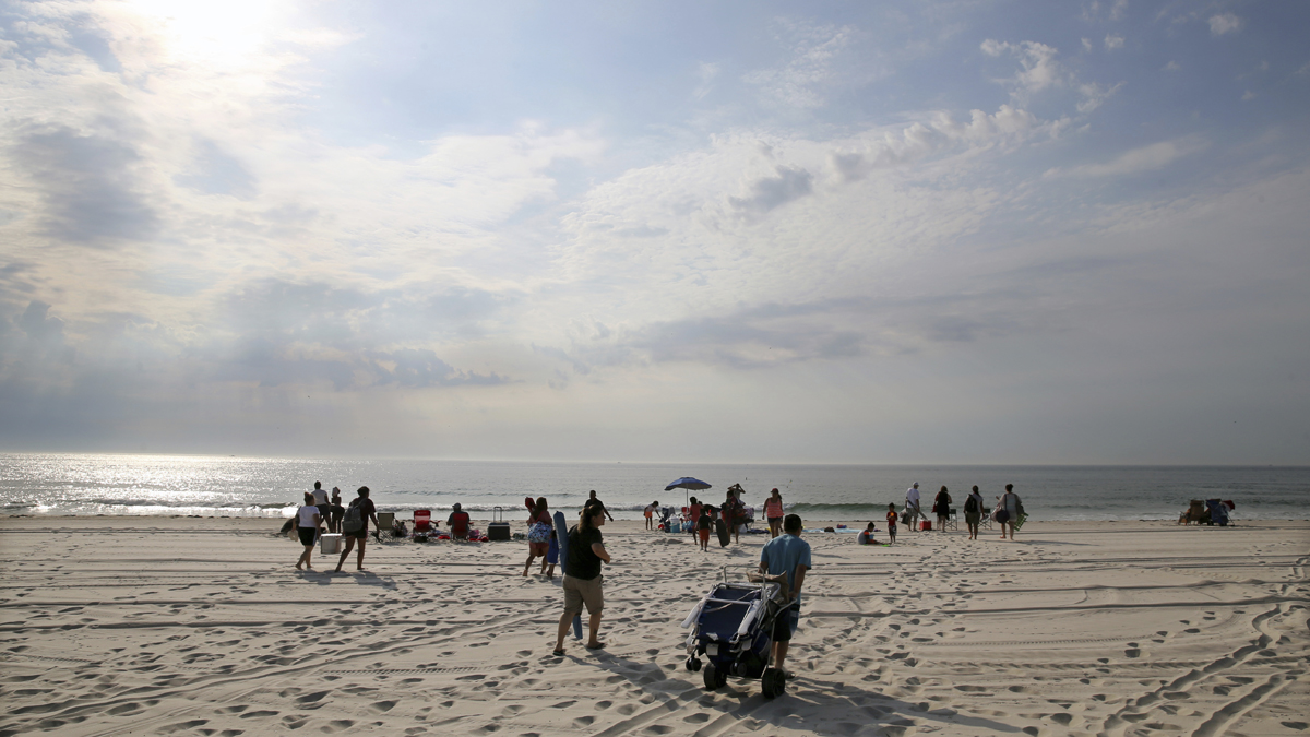  People stream onto the beach at Island Beach State Park after it reopened at 8 in the morning July 4 in Seaside Park, N.J. New Jersey's budget stalemate between Republican Gov. Chris Christie and the Democrat-controlled Legislature led to a state government shut down, and state parks closed to the public until late Monday night, just in time for the Fourth of July. (AP Photo/Mel Evans) 