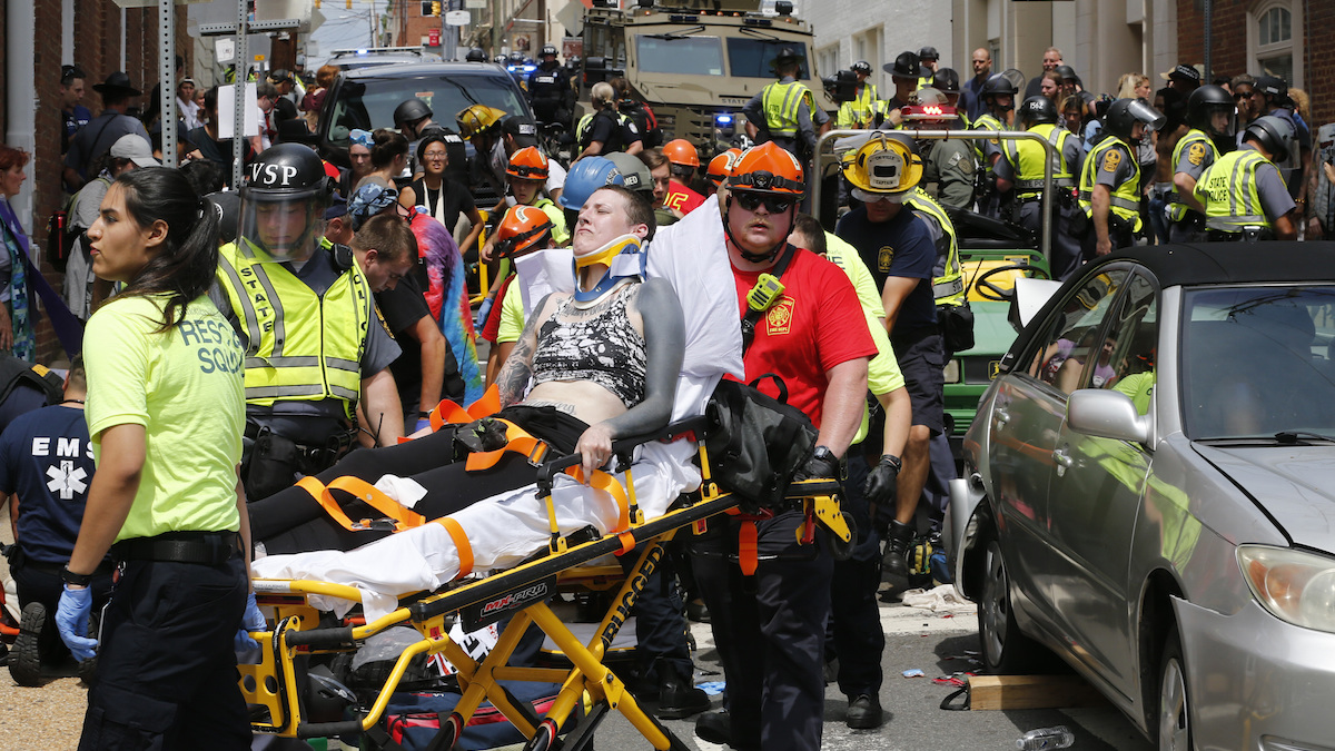  Rescue personnel help injured people after a car ran into a large group of protesters after a white nationalist rally in Charlottesville, Va., Saturday, Aug. 12, 2017. The nationalists were holding the rally to protest plans by the city of Charlottesville to remove a statue of Confederate Gen. Robert E. Lee. There were several hundred protesters marching in a long line when the car drove into a group of them. (AP Photo/Steve Helber) 