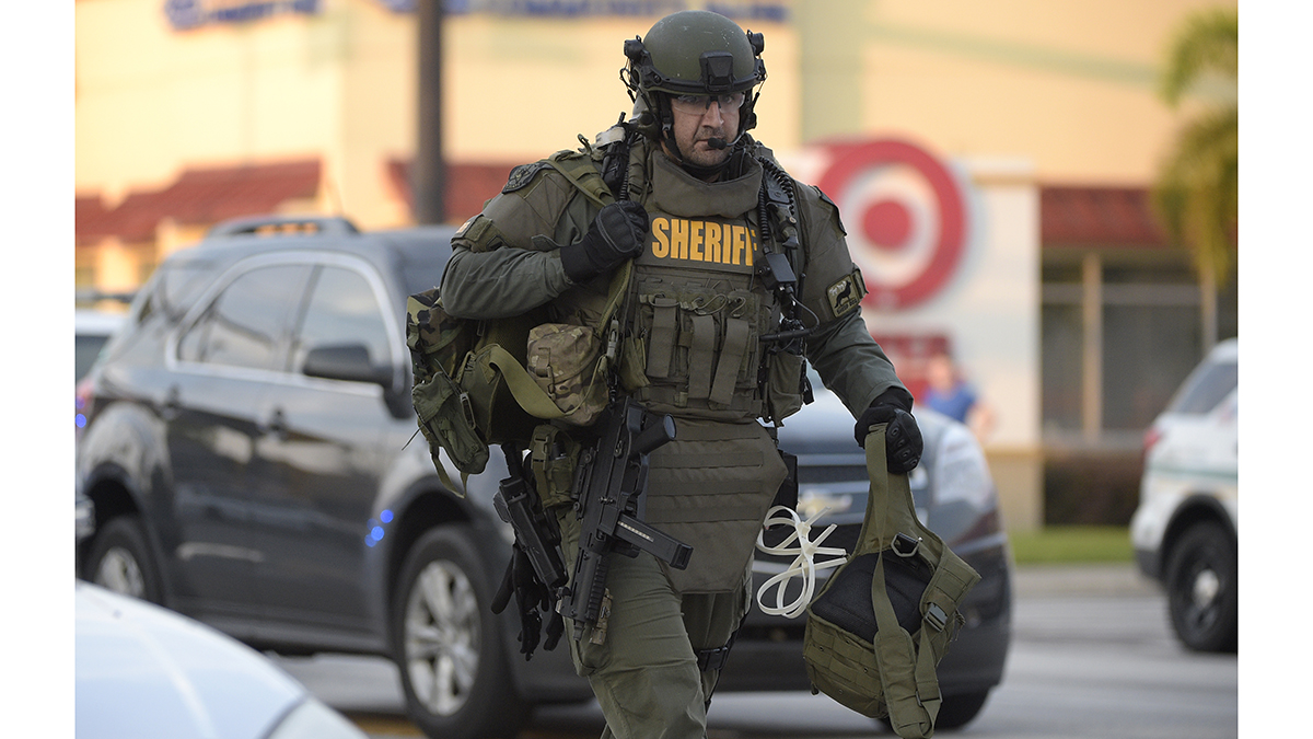 A police officer arrives down the street after a shooting involving multiple fatalities at the Pulse Orlando nightclub in Orlando