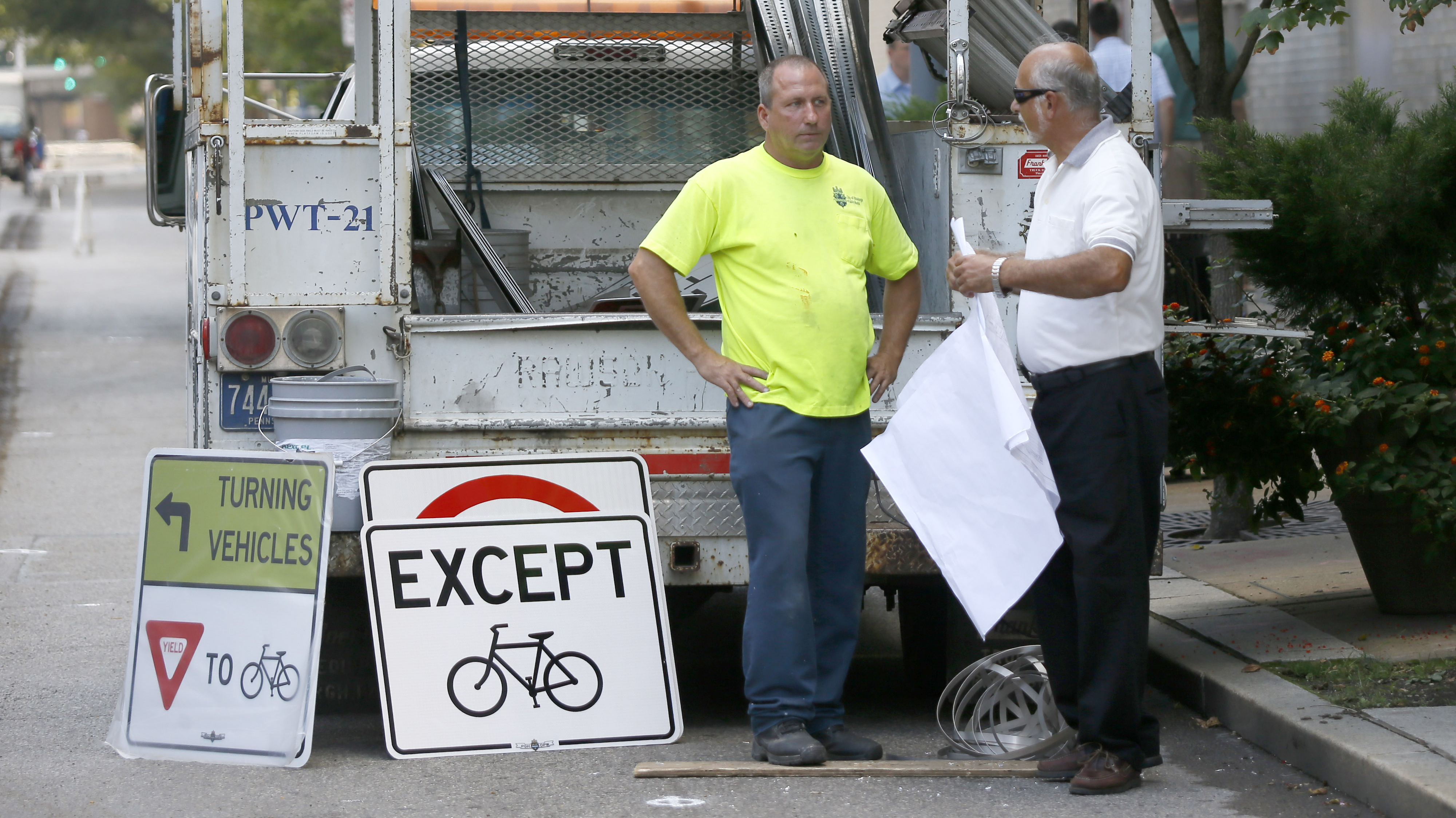  Public works employees prepare to change signs along the eastbound lane of Penn Ave. in downtown Pittsburgh, Pa. on Wednesday, Sept. 3, 2014. City officials closed the eastbound lane from 6th Street in downtown to 16th Street in the city's Strip District to motor vehicles and made it a protected bicycle lane. (AP Photo/Keith Srakocic) 