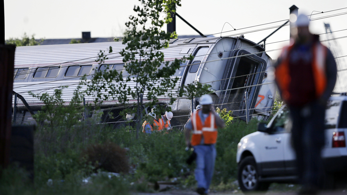 Emergency personnel walk near the scene of a deadly train wreck, Wednesday, May 13, 2015, in Philadelphia. An Amtrak train headed to New York City derailed and crashed in Philadelphia on Tuesday night. (AP Photo/Mel Evans)