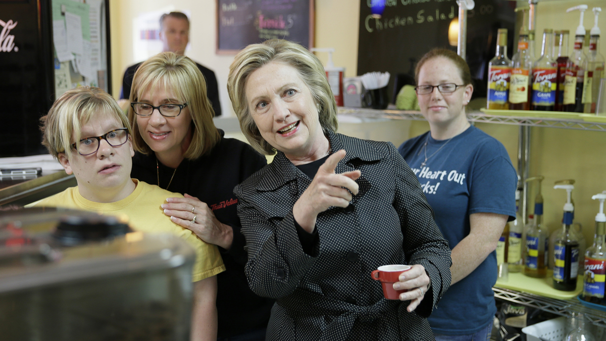  Democratic presidential candidate Hillary Rodham Clinton talks to shop owner Emilea Hillman, left, and Hillman's mother Tami Fenner as she stops at Em's Coffee Co., Tuesday, May 19, 2015, in Independence, Iowa. (Charlie Neibergall/AP Photo) 