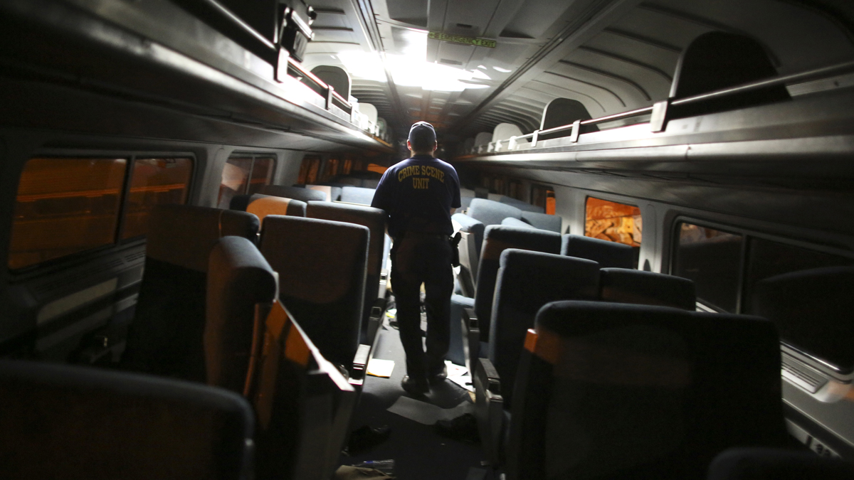 A crime scene investigator looks inside a train car after a train wreck, Tuesday, May 12, 2015, in Philadelphia. An Amtrak train headed to New York City derailed and crashed in Philadelphia.
