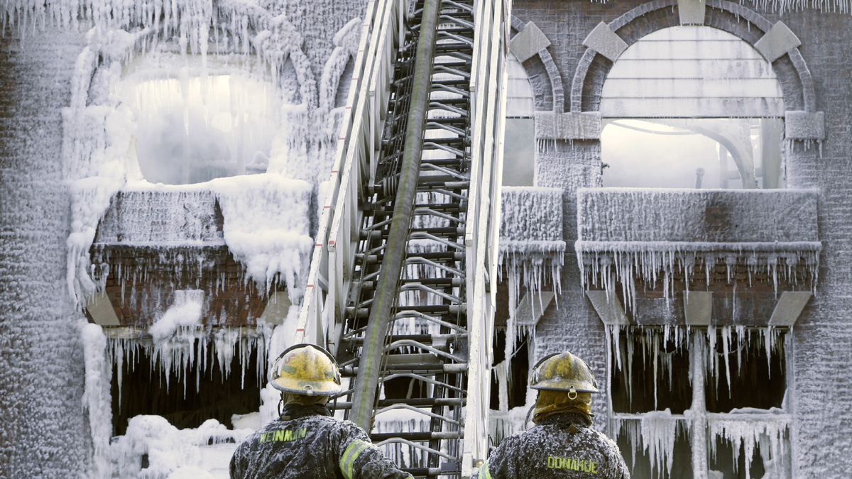  Philadelphia firefighters work the scene of an overnight blaze in West Philadelphia Monday as icicles hang from where the water from their hoses froze. (Jacqueline Larma/AP Photo)  