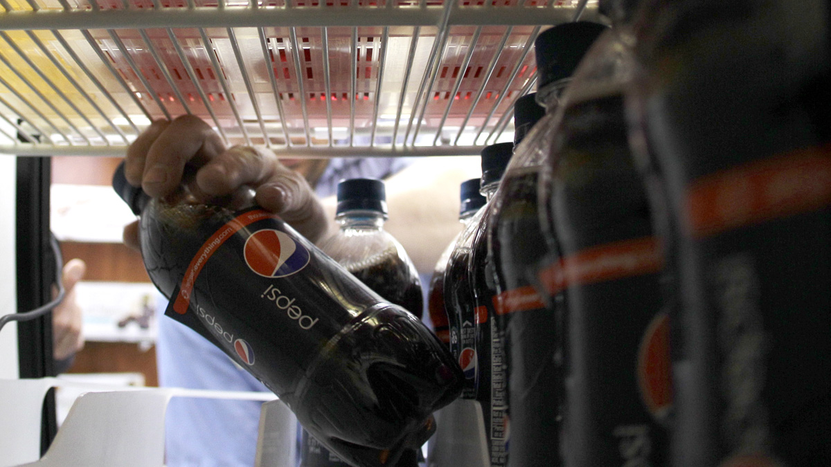 In this photo taken Oct. 4, 2010, Chris Shook, a driver with Harbor Pacific Bottling Inc., stocks a cooler with soda, in Elma, Wash. Washington state consumers started paying more this summer for candy, gum and carbonated beverages, but the main muscle behind the effort to overturn those new taxes is the soda industry, which is helping fund advertising for an initiative that seeks to repeal a temporary tax on carbonated beverages and bottled water, the sales tax on candy and gum, and to reduce business and occupation rates for some food processors. (AP Photo/Ted S. Warren)