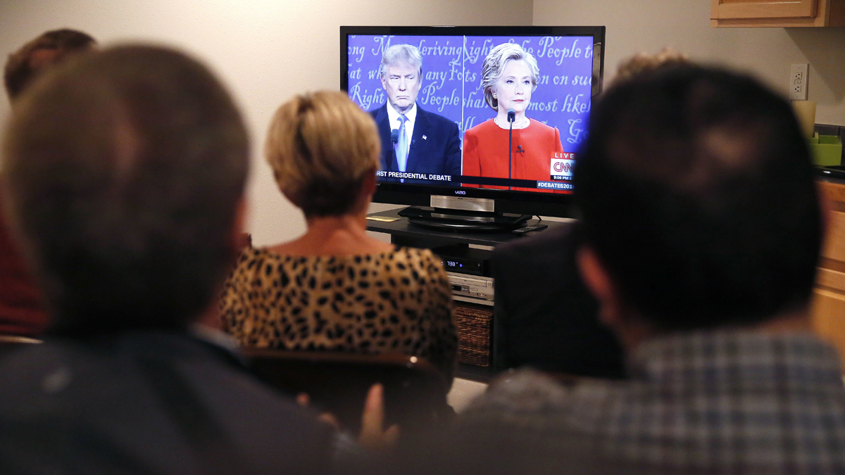  A bipartisan group of friends and colleagues of two former Colorado lawmakers from both sides of the aisle, former US Rep. Spencer Swalm, a Republican, and former US Rep. Joe Miklosi, a Democrat, listen to the first presidential debate during a watch party at Swalm's house in Centennial, Colo., Monday, Sept. 26, 2016. (Brennan Linsley/AP Photo)  