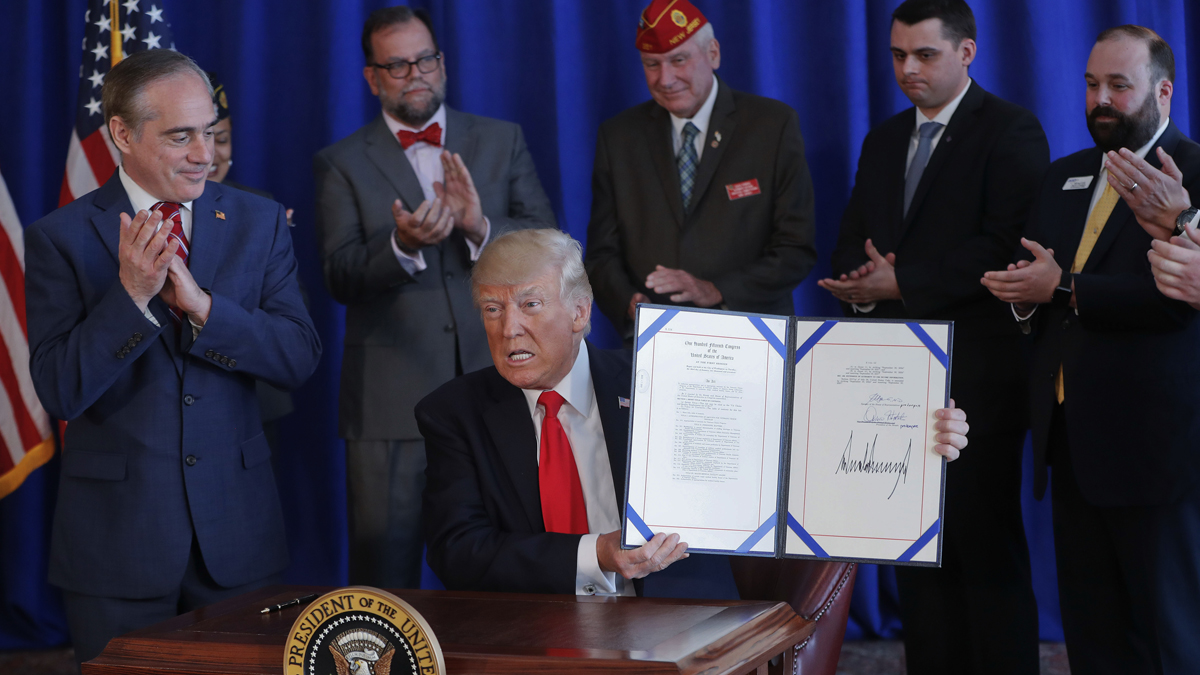  President Donald Trump holds the Veteran's Affairs Choice and Quality Employment Act of 2017 after signing it at Trump National Golf Club in Bedminister, N.J., Saturday, Aug. 12, 2017. Standing with Trump is Veterans Affairs Secretary David Shulkin, left. (Pablo Martinez Monsivais/AP Photo) 
