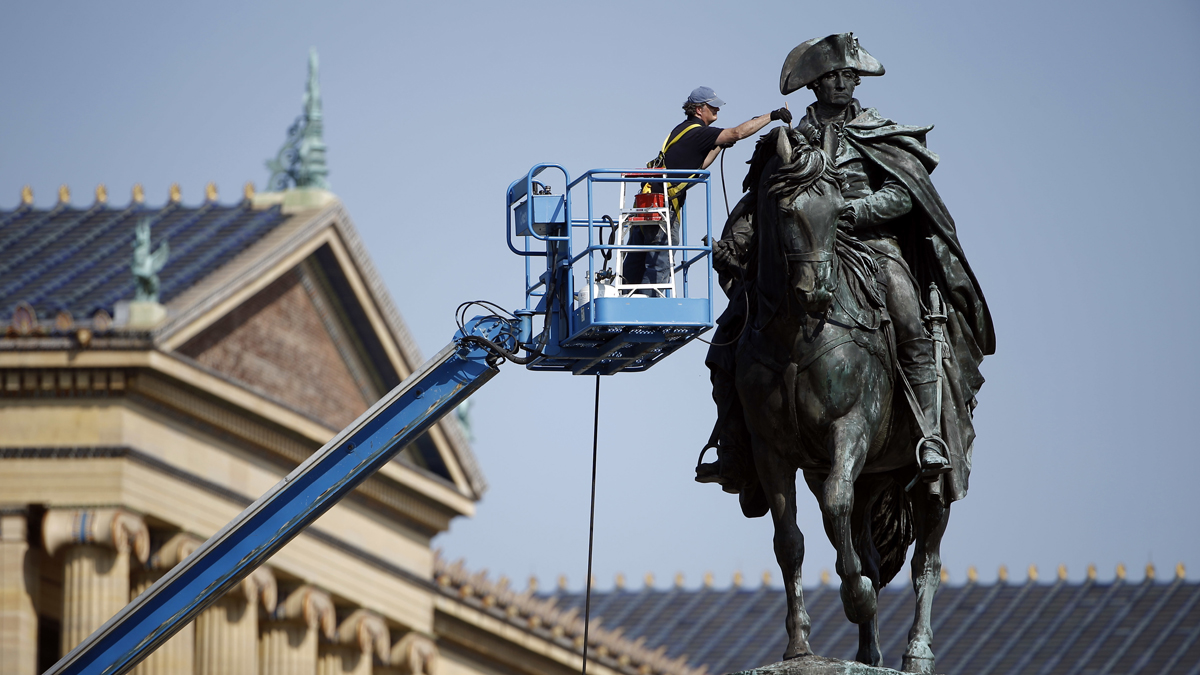 Art conservator Douglas Martenson applies a patina to a bronze statue of George Washington that stands near the Philadelphia Museum of Art. In honor of Labor Day