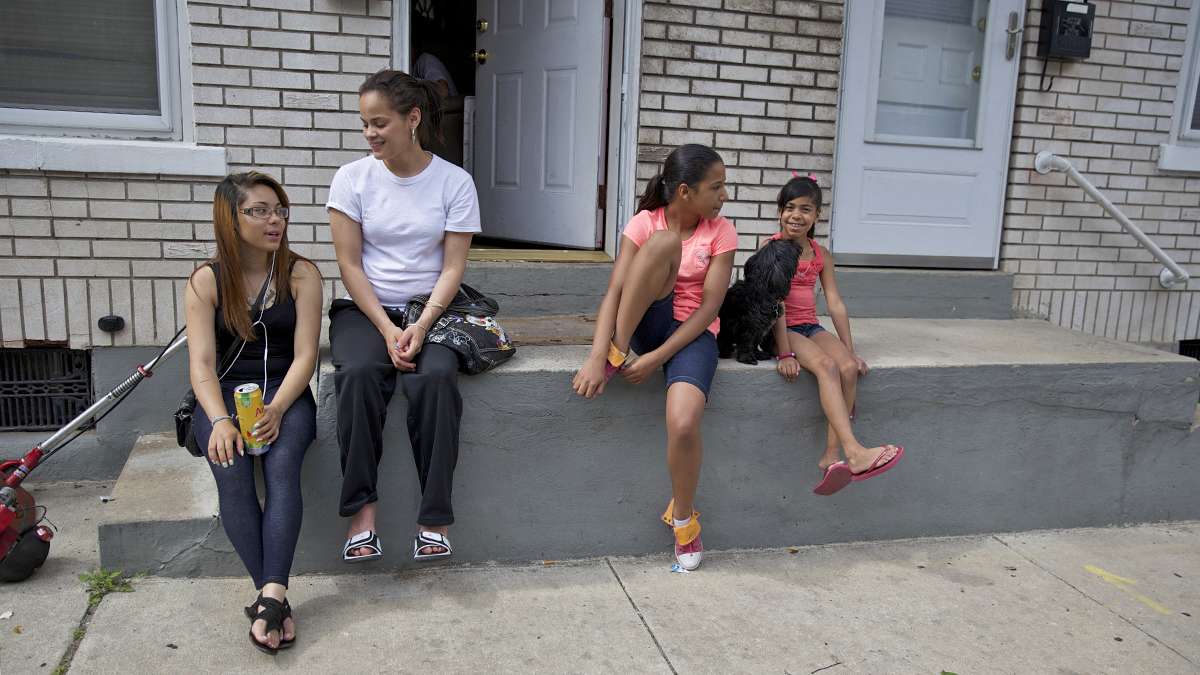 Zeanna Riveria, 18, Elizabeth Alejandro, 20, Nariah Jimenez, 11, and younger sister sit on the stoop of a South Bethlehem house. (Lindsay Lazarski/WHYY)