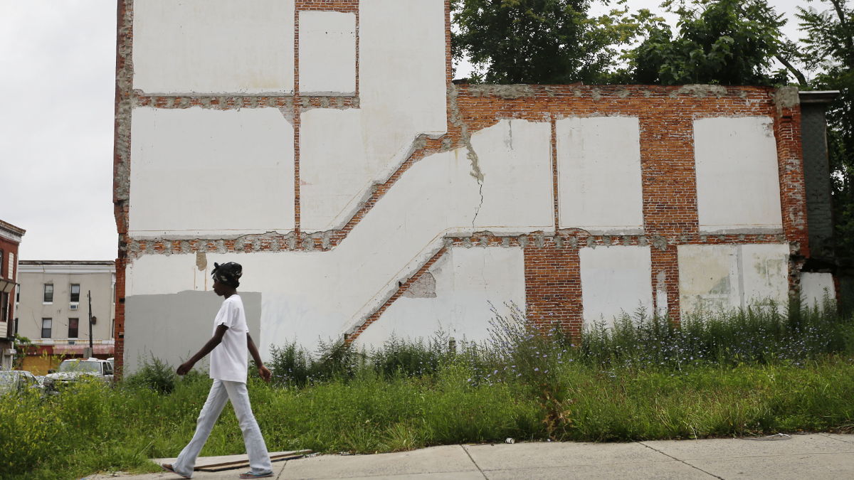 A woman walks through a Philadelphia neighborhood. (AP Photo/Matt Rourke)