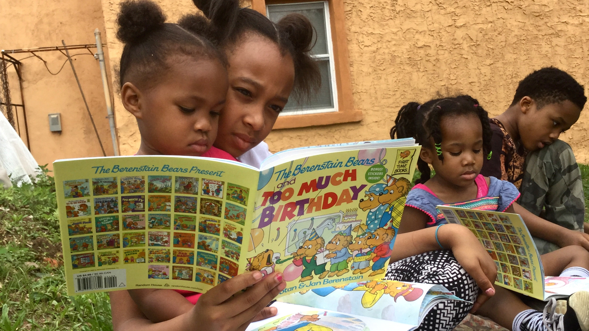 Zahiyah Ambrose and Zion Norton share a birthday themed book at the Books and Breakfast Philly's second anniversary. (Kyrie Greenberg/WHYY)