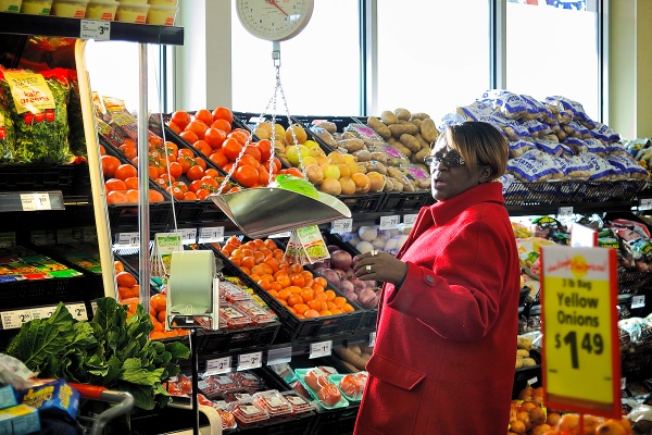 A customer weighs a head of lettuce in the produce aisle. (Bas Slabbers/for NewsWorks)