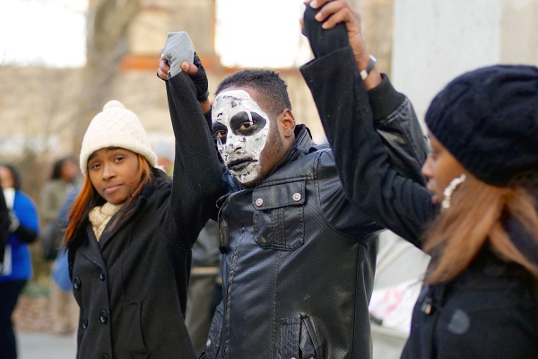 <p><p>Charles and his fellow dance-group members raise their hands in support of the rally. (Bas Slabbers/for NewsWorks)</p></p>
