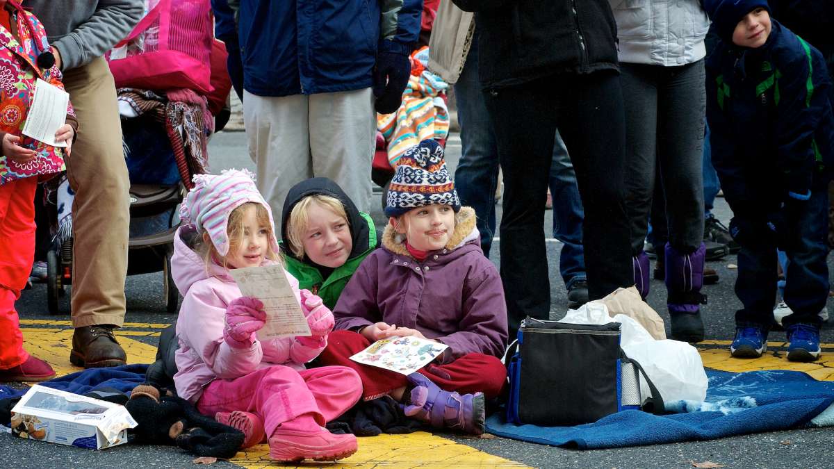 hildren watch as Mr. and Mrs. Santa make their way past. (Bas Slabbers/for NewsWorks)