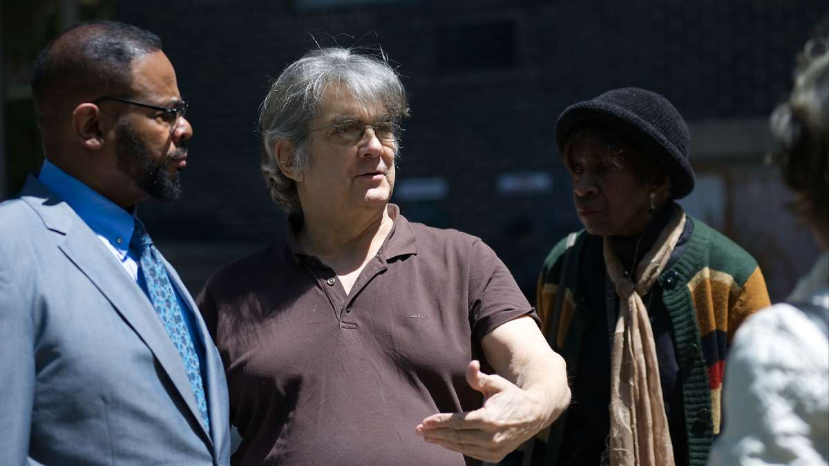 Councilman Curtis Jones, Jr. listens to Craig Cheney (center), one of the residents at Penn Wynn House who rally against imminent eviction during a rally outside the apartment building in Wynnefield, on Wednesday.