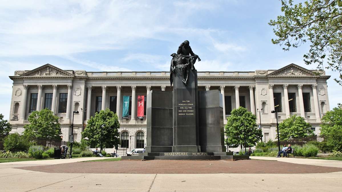 This memorial to Shakespeare in front of the Central Branch of the Philadelphia Free Library comprises two figures that represent tragedy and comedy: Hamlet, leaning his head against a knife; and King Lear's jester, Touchstone, with his head thrown back in laughter. (Kimberly Paynter/WHYY)