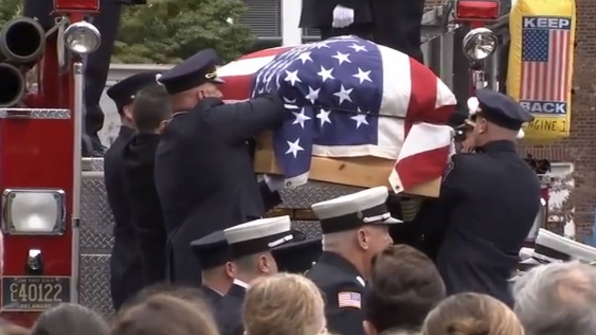 Lt. Chris Leach's casket is lowered from the back of a Wilmington Fire Dept. truck before his funeral. (John Jankowski/for NewsWorks)