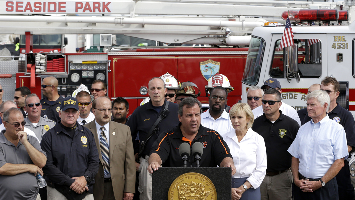  New Jersey Gov. Chris Christie, center, talks during a news conference,  the morning after a massive fire burned a large portion of the Seaside Park boardwalk. (AP Photo/Julio Cortez) 