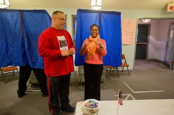 <p><div style="margin: 0px; font: 10px 'Lucida Grande';"><span style="font-size: 12pt;">Armstead King, judge of elections, watches as Eighth District City Councilwoman Cindy Bass exits the voting booth after casting her ballot at Germantown Christian Academy. (Dave Tavani/ for NewsWorks)</span></div></p>
