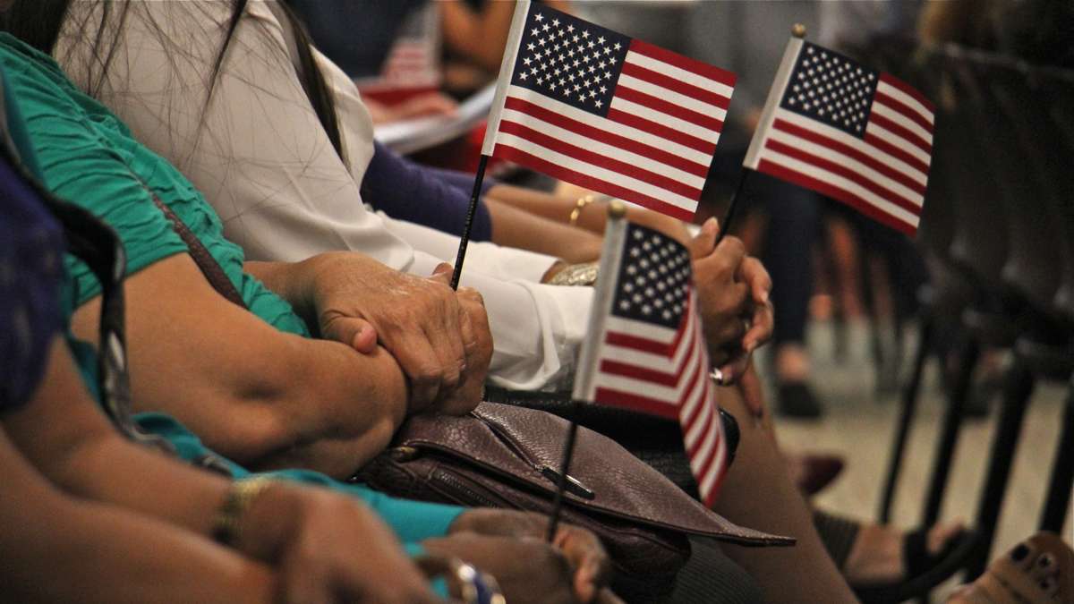 New citizens wait to take the oath of allegiance during a naturalization ceremony in Philadelphia. (Emma Lee/WHYY, file) 