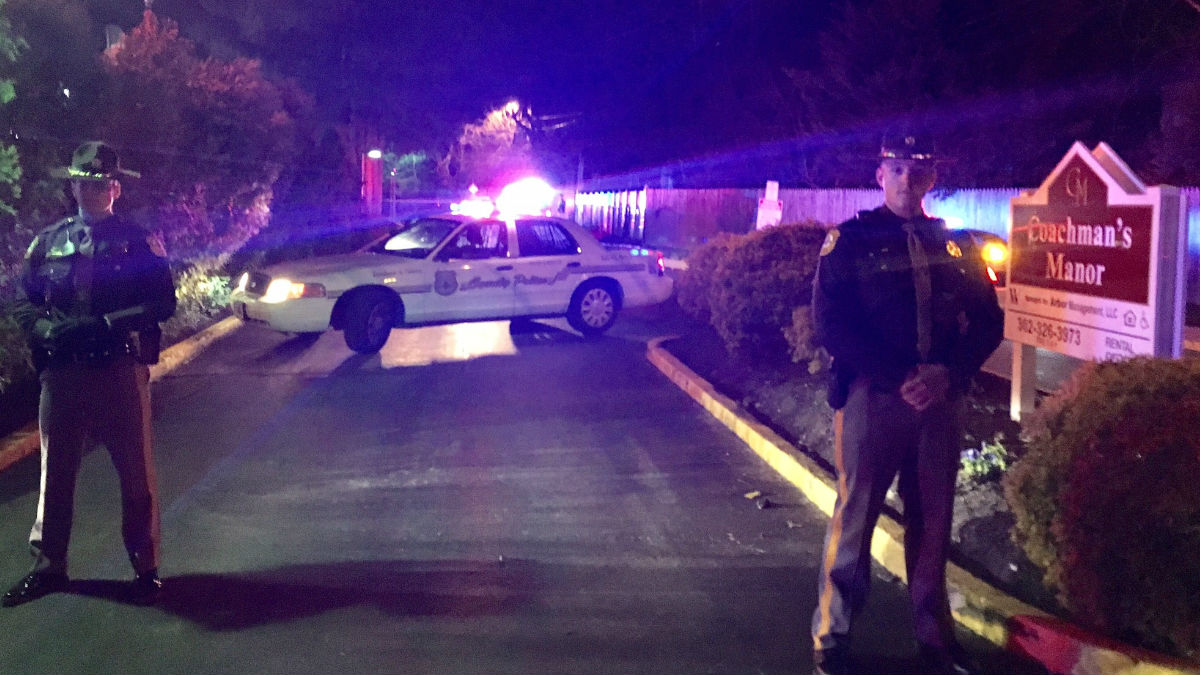  New Castle County Police guard the entrance to the Coachman's Manor apartments after an officer was involved in a shooting that left a 28-year-old Philadelphia man dead. (John Jankowski/for NewsWorks) 